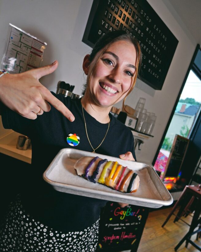 A worker from Donut Monster showcasing a rainbow donut to celebrate pride